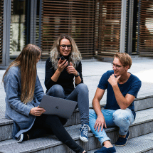 college students sitting in front of the campus