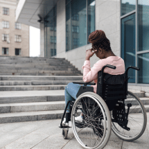a person with disability in front of a school